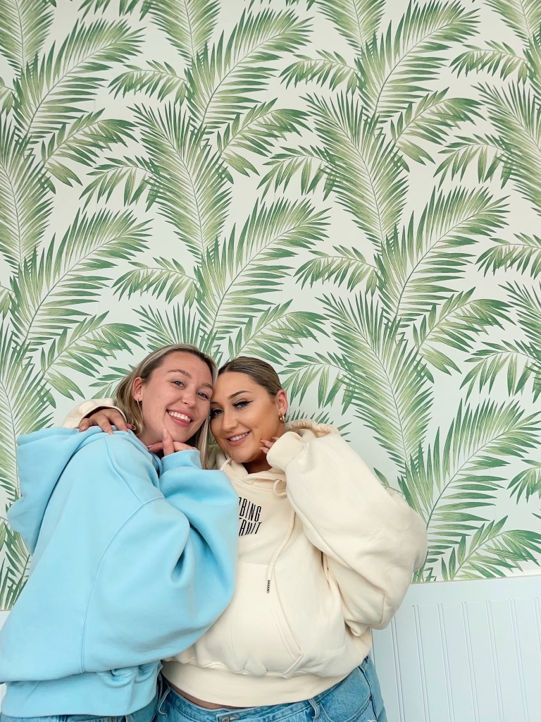 Two friends posing next to each other.