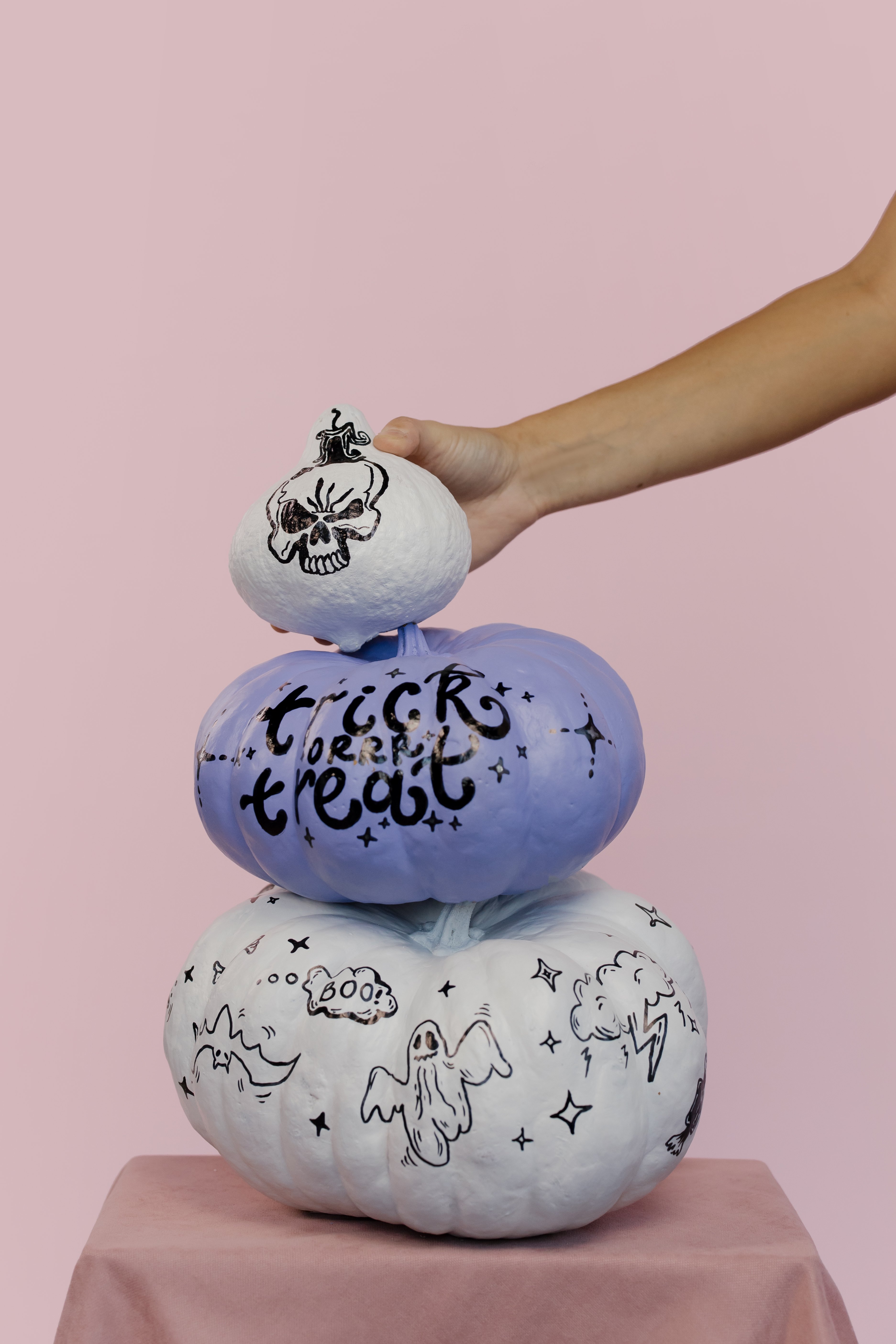 three painted pumpkins stacked on each other