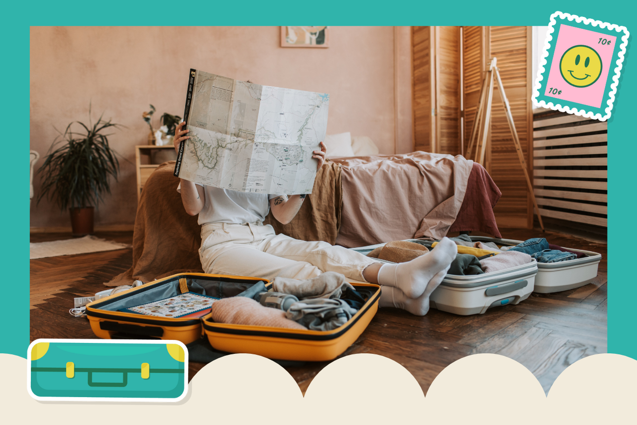 woman looking at map while packing suitcases