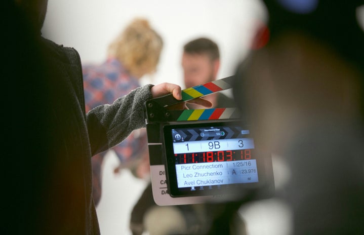 Clapperboard and two people behind.