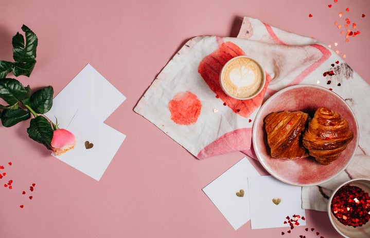 a pink table topped with a plate of food and cup of coffee