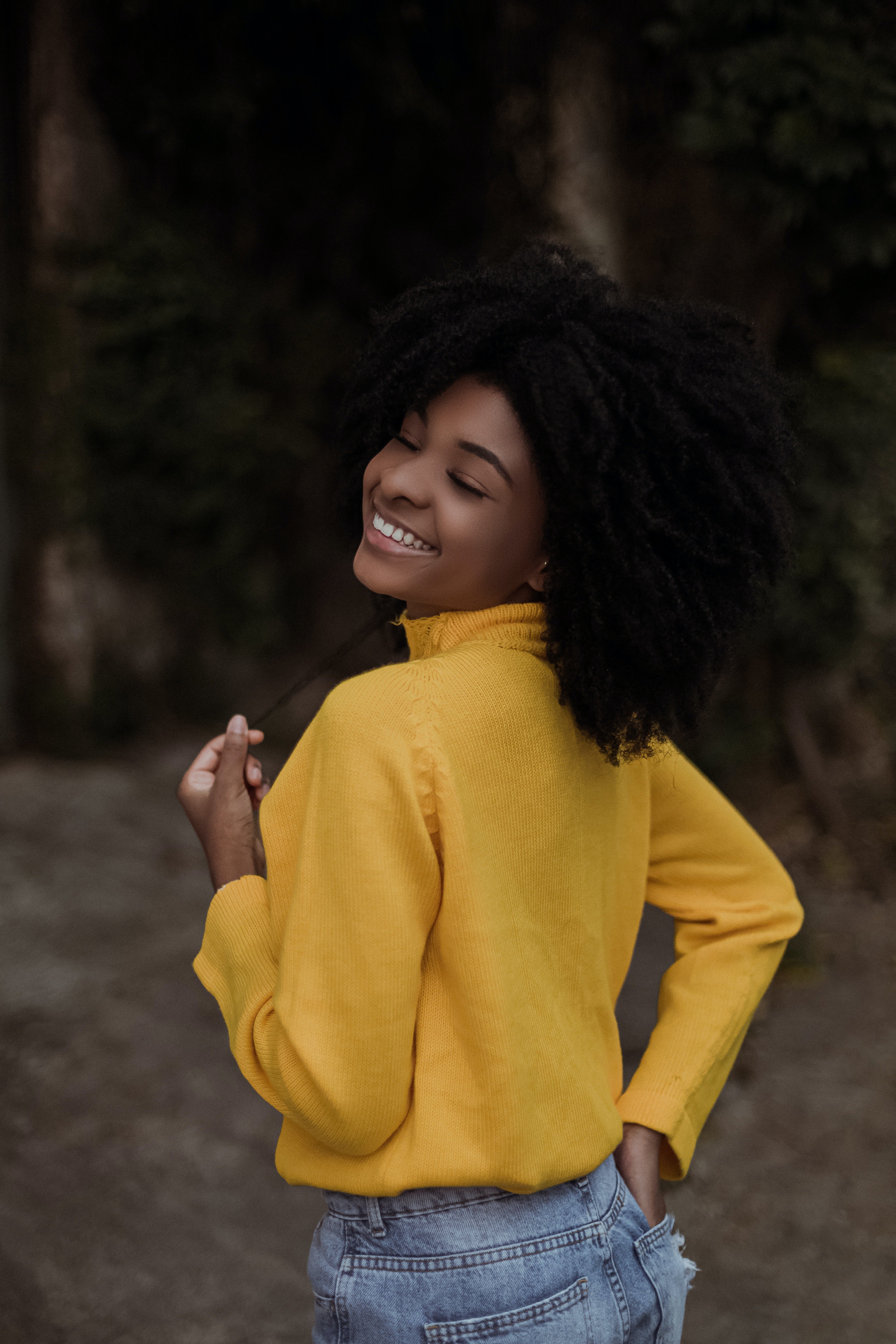 young woman smiling in yellow sweater