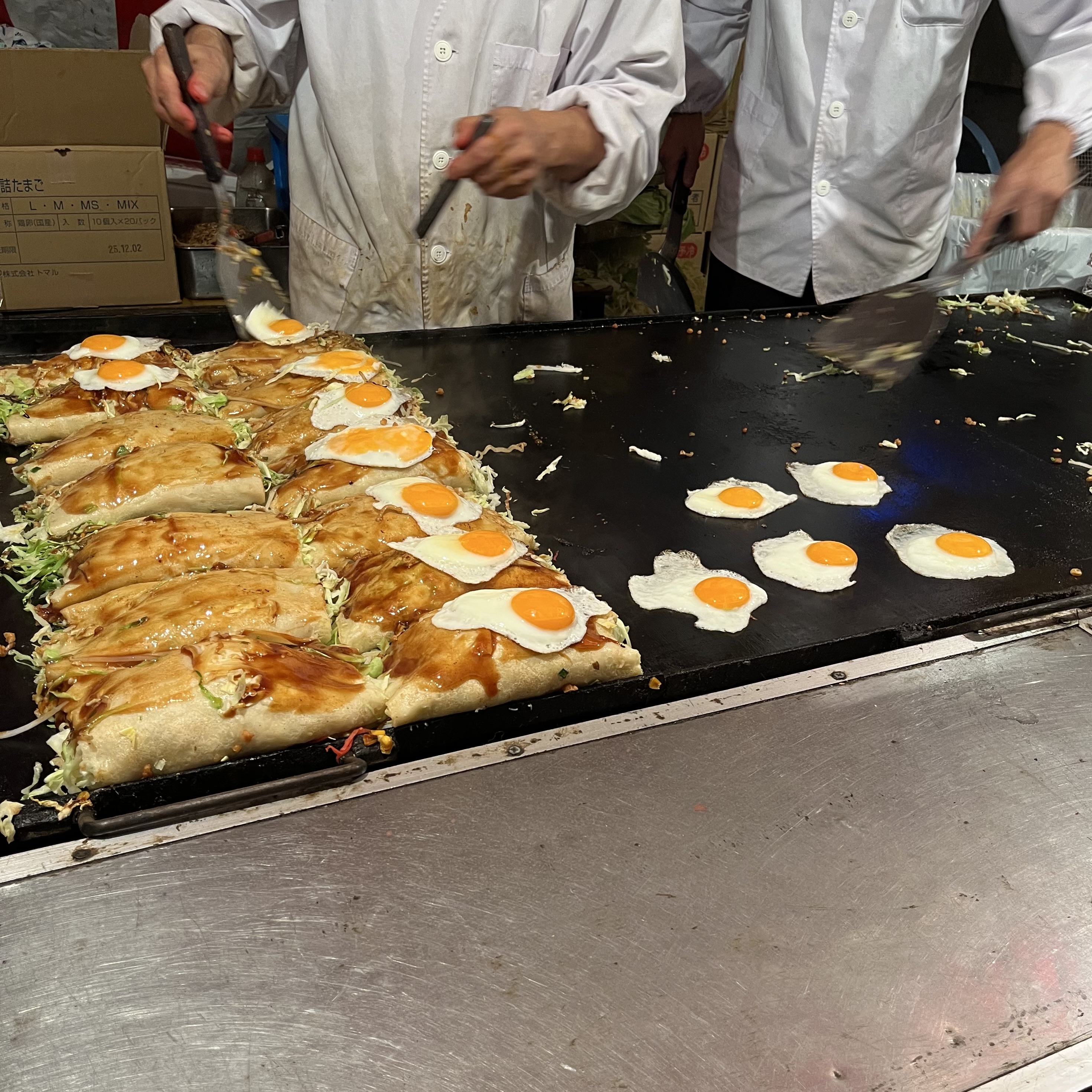 The stall vendor cooked okonomiyaki