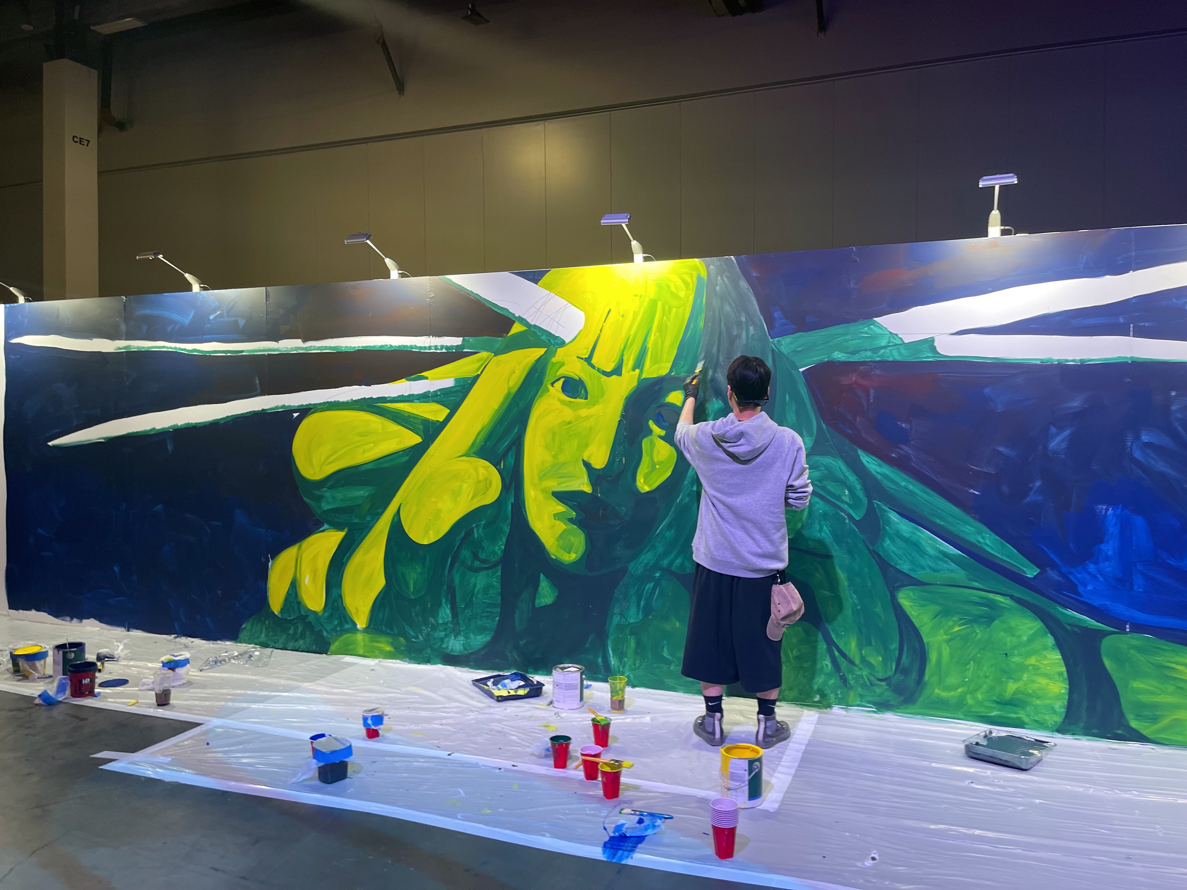 Artist painting at live painting exhibit at festival