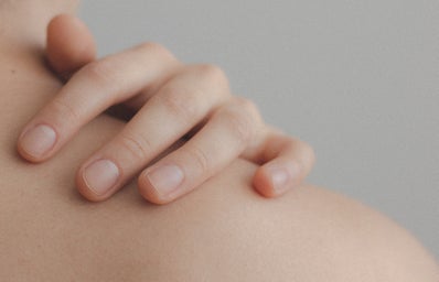 A close up on someones hand touching their back