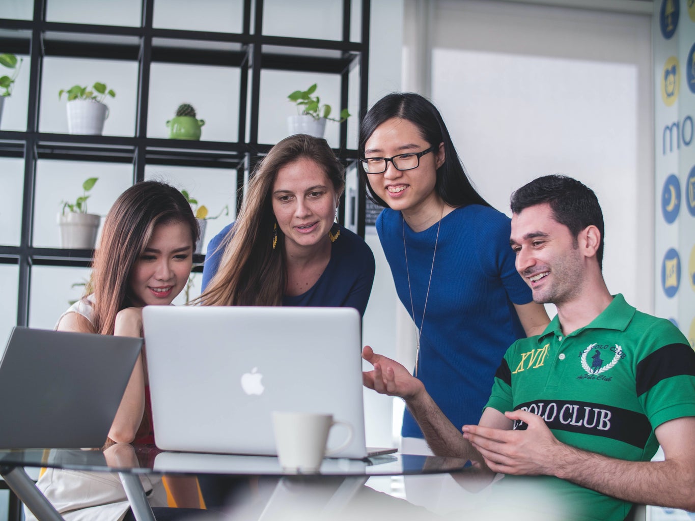 group of people surrounding laptop