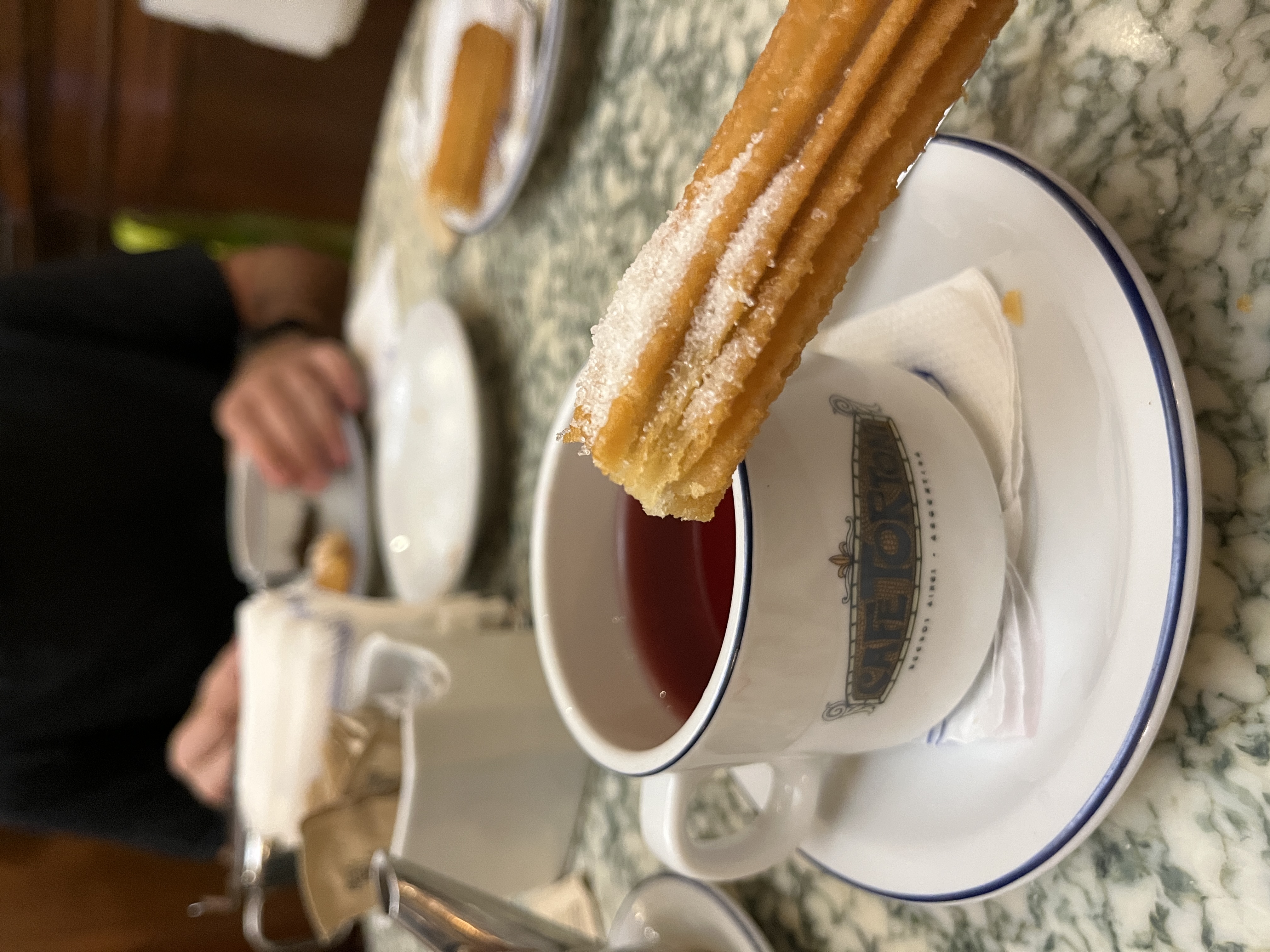 A churro and a glass of tea are placed on a table