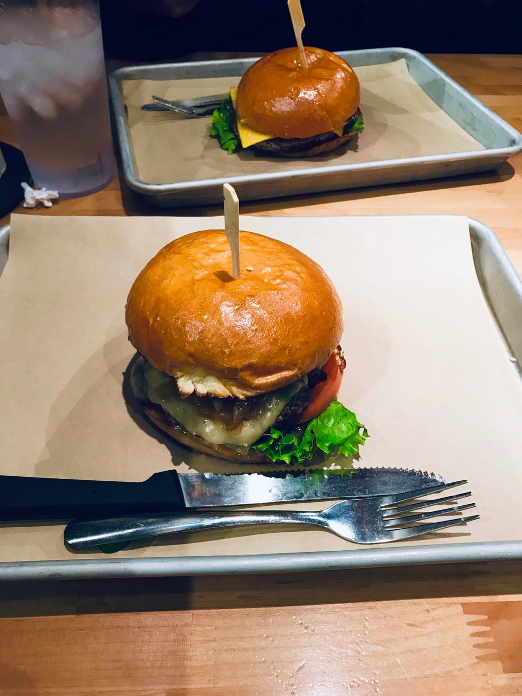 two burgers on separate metal trays