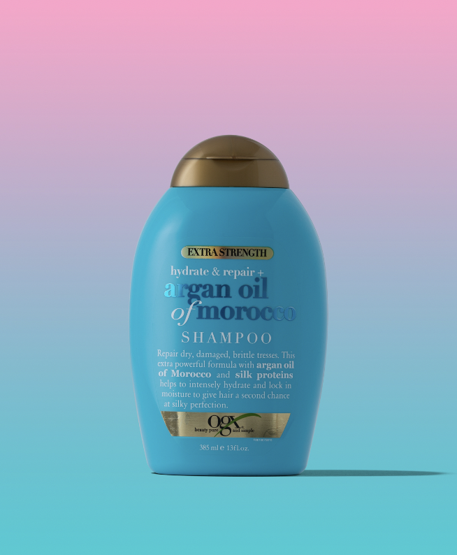 Bottle of hair product in front of an ombre pink and blue background