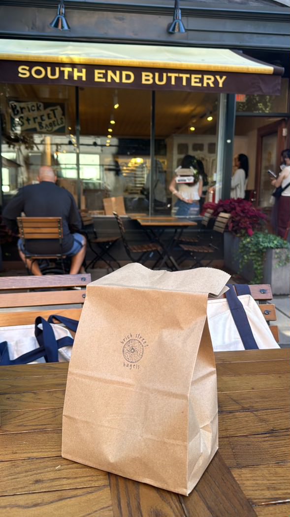 paper bag with brick street bagels written, and cafe in the back