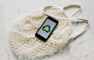 reusable produce bag with smartphone on top showing recycling logo