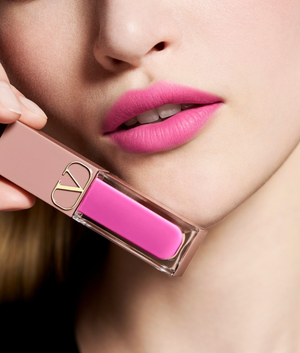 model wearing Valentino Beauty lip color in front of a white background