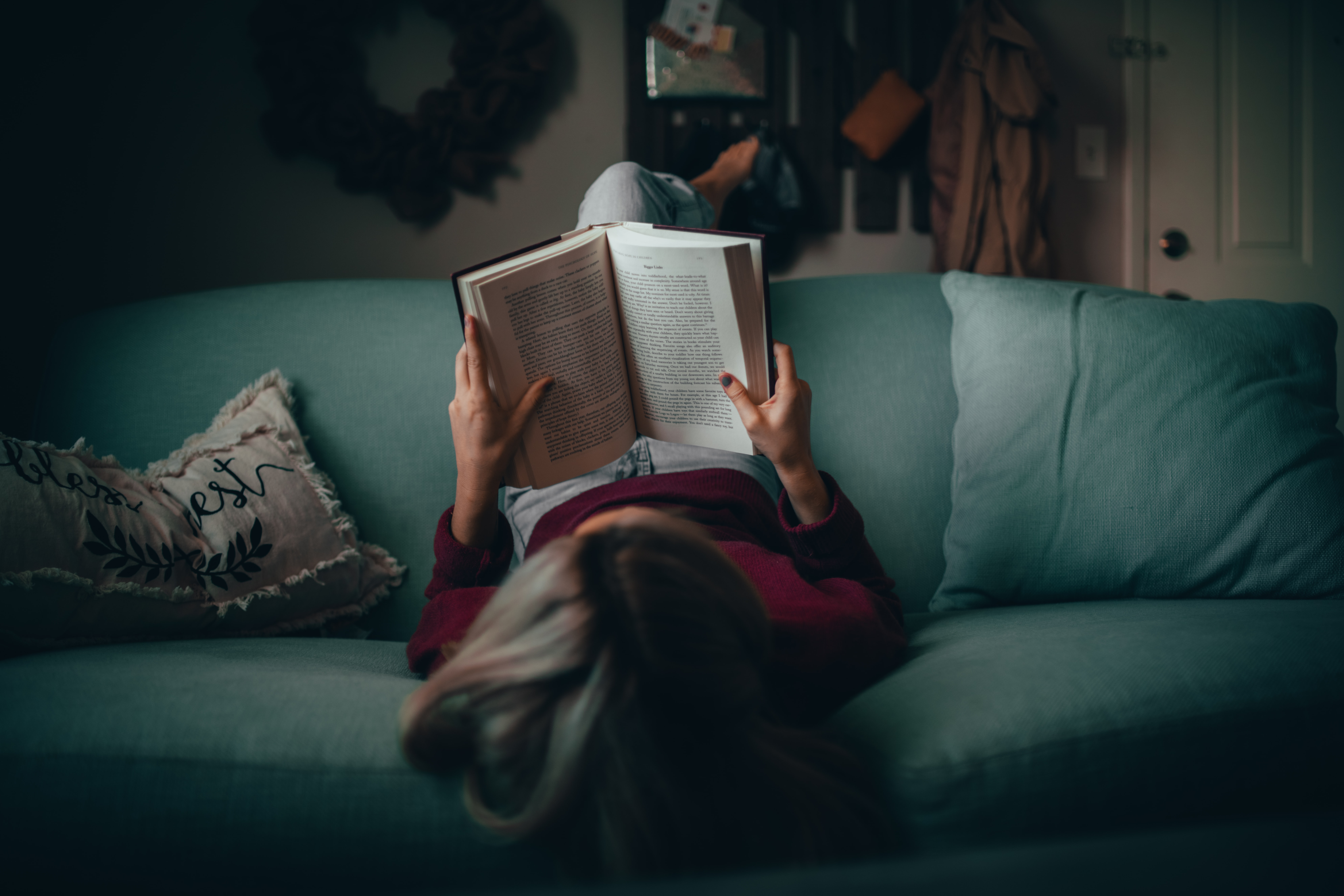 A woman reading on a couch.
