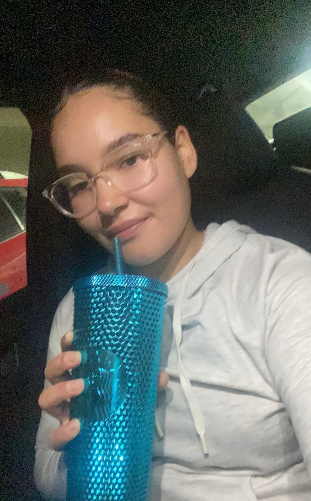 Gloria sipping from a Starbucks blue tumbler