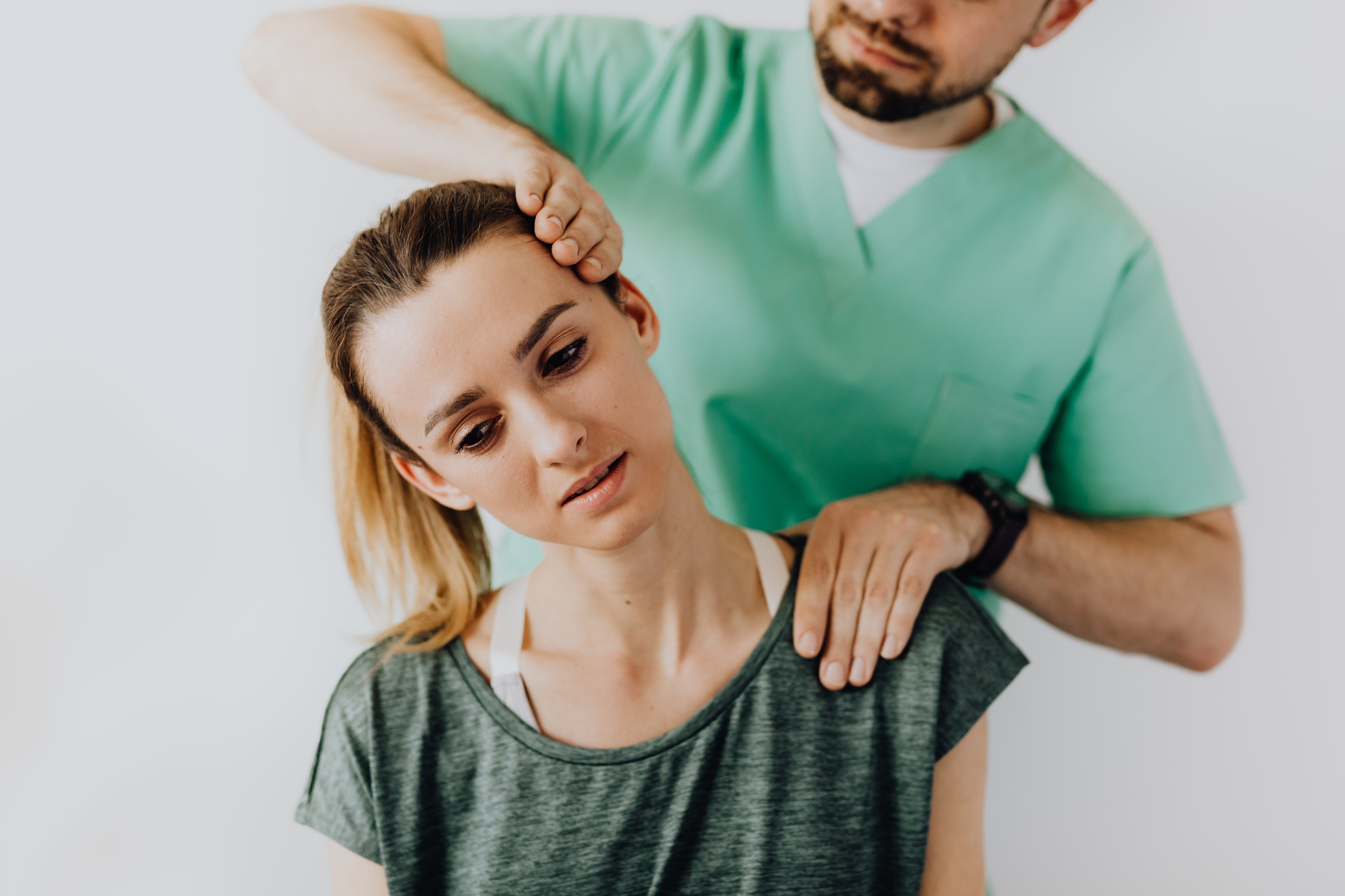 A doctor stretching a woman\'s neck.