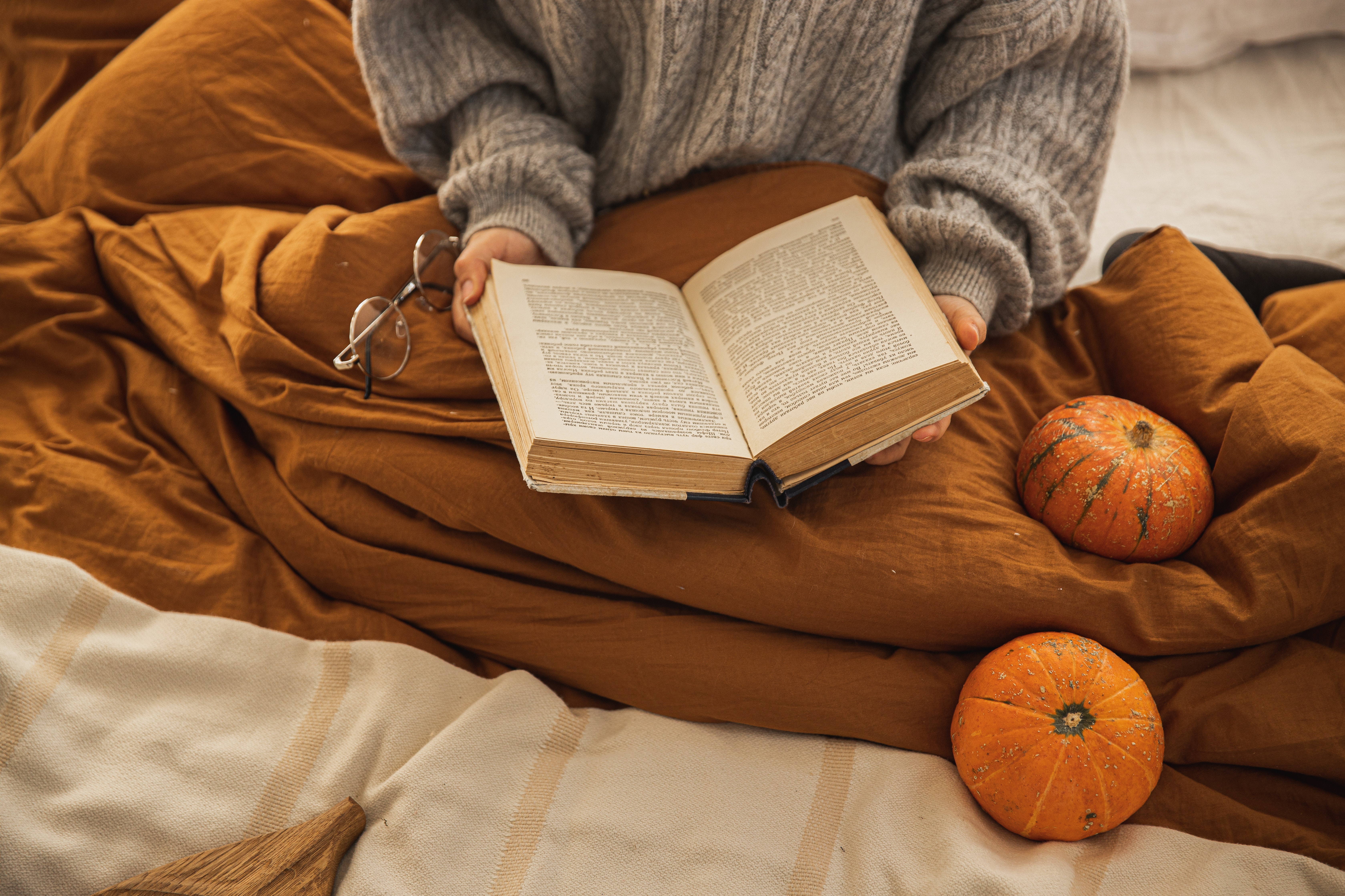 woman reading a book pumpkins