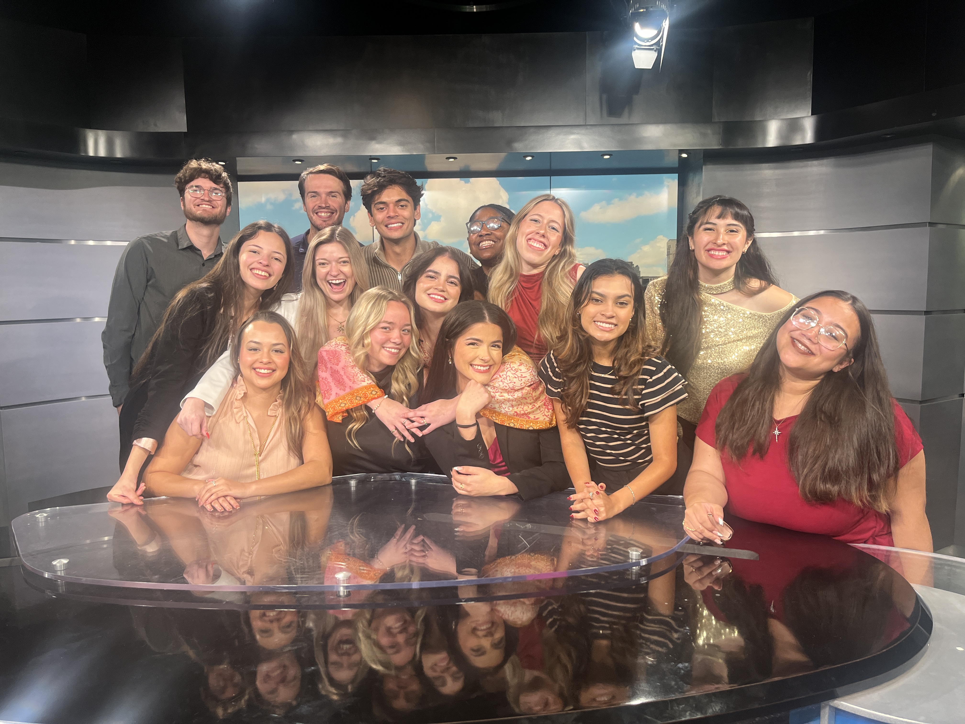 A group of student journalists posing for a photo for their final newscast