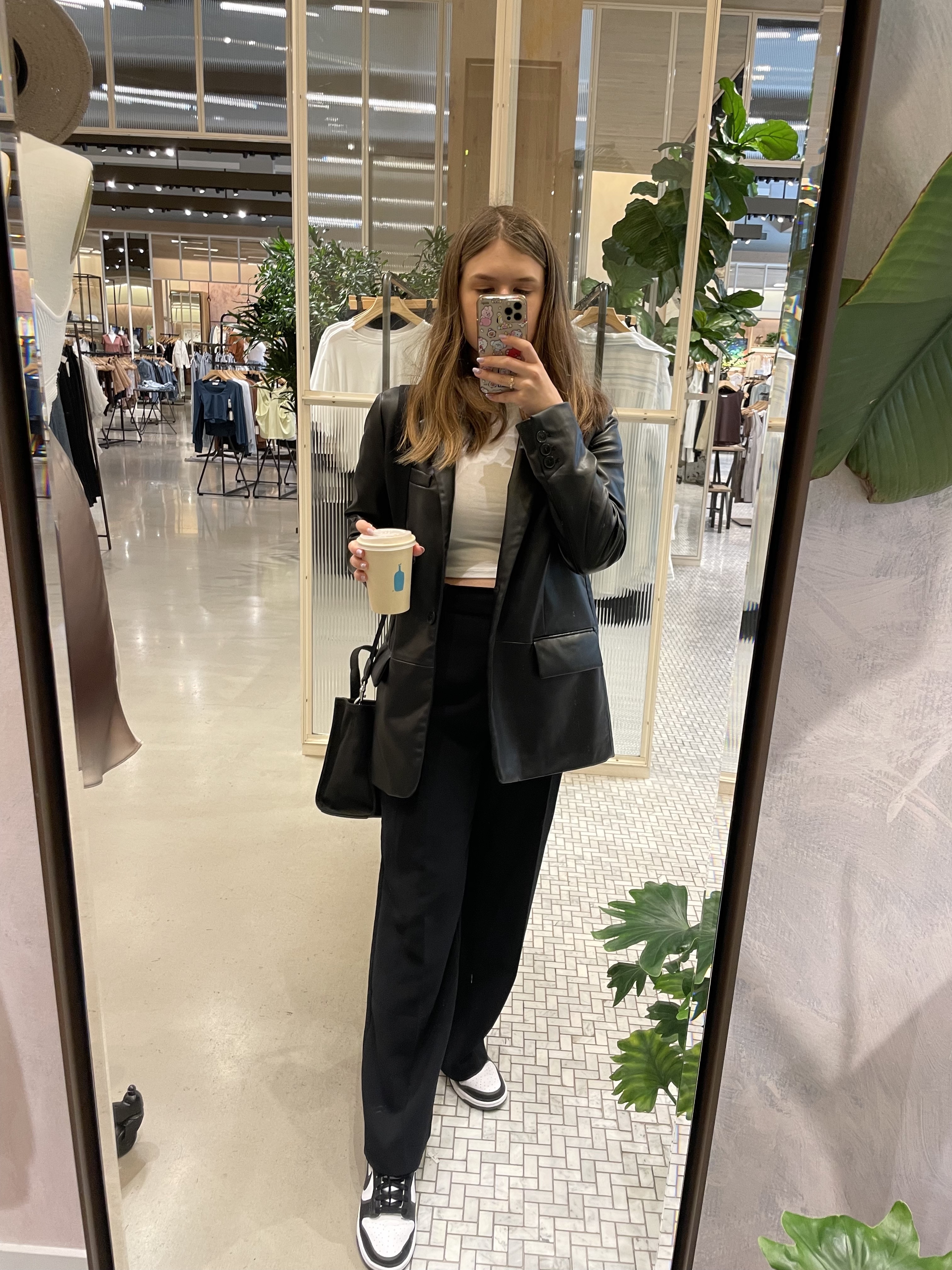girl wearing black blazer holding coffee