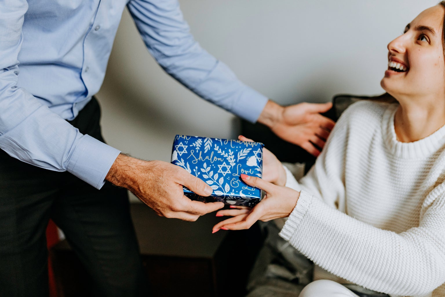 woman receiving wrapped hanukkah present