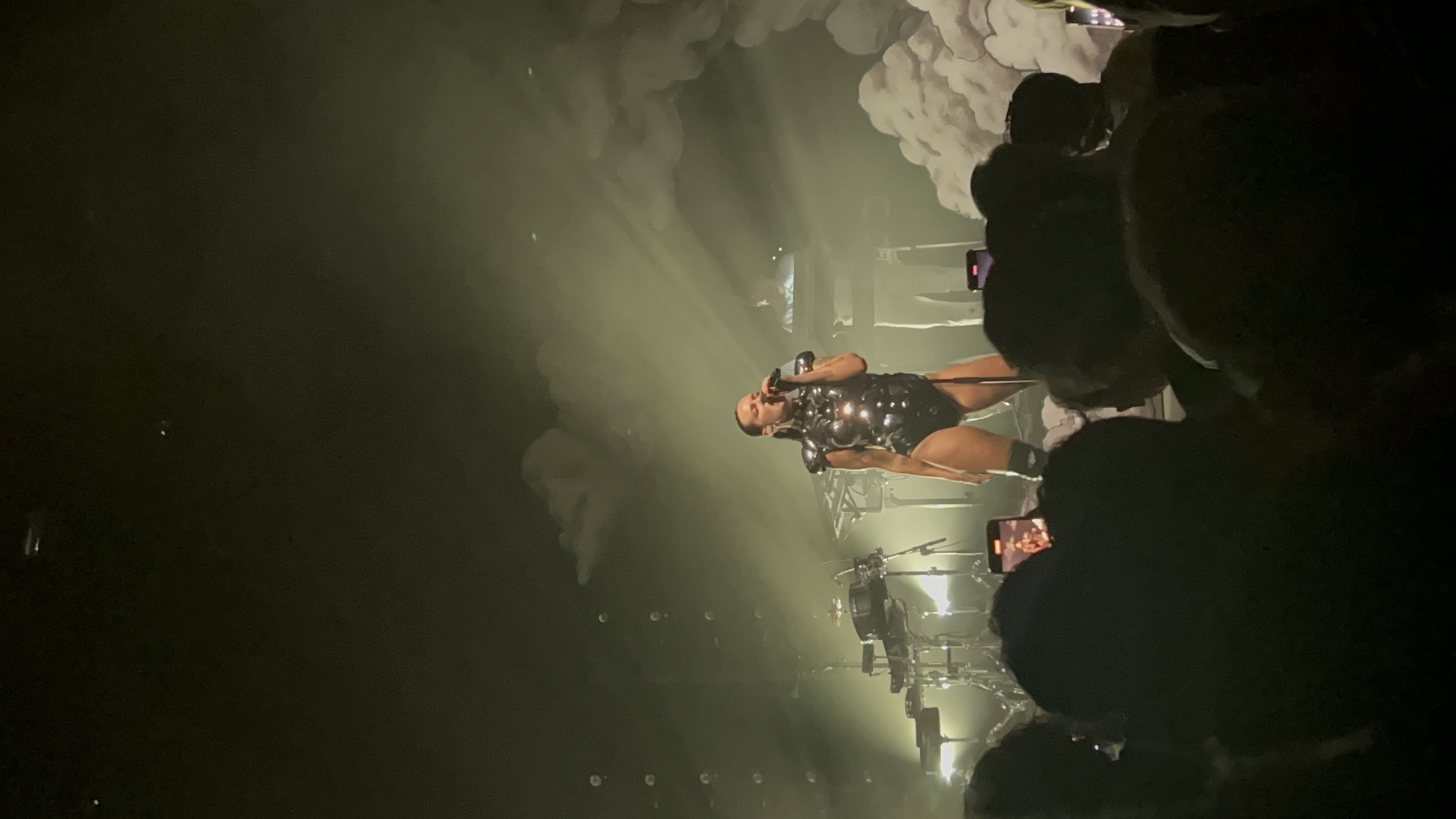 Woman singing on stage in a black outfit