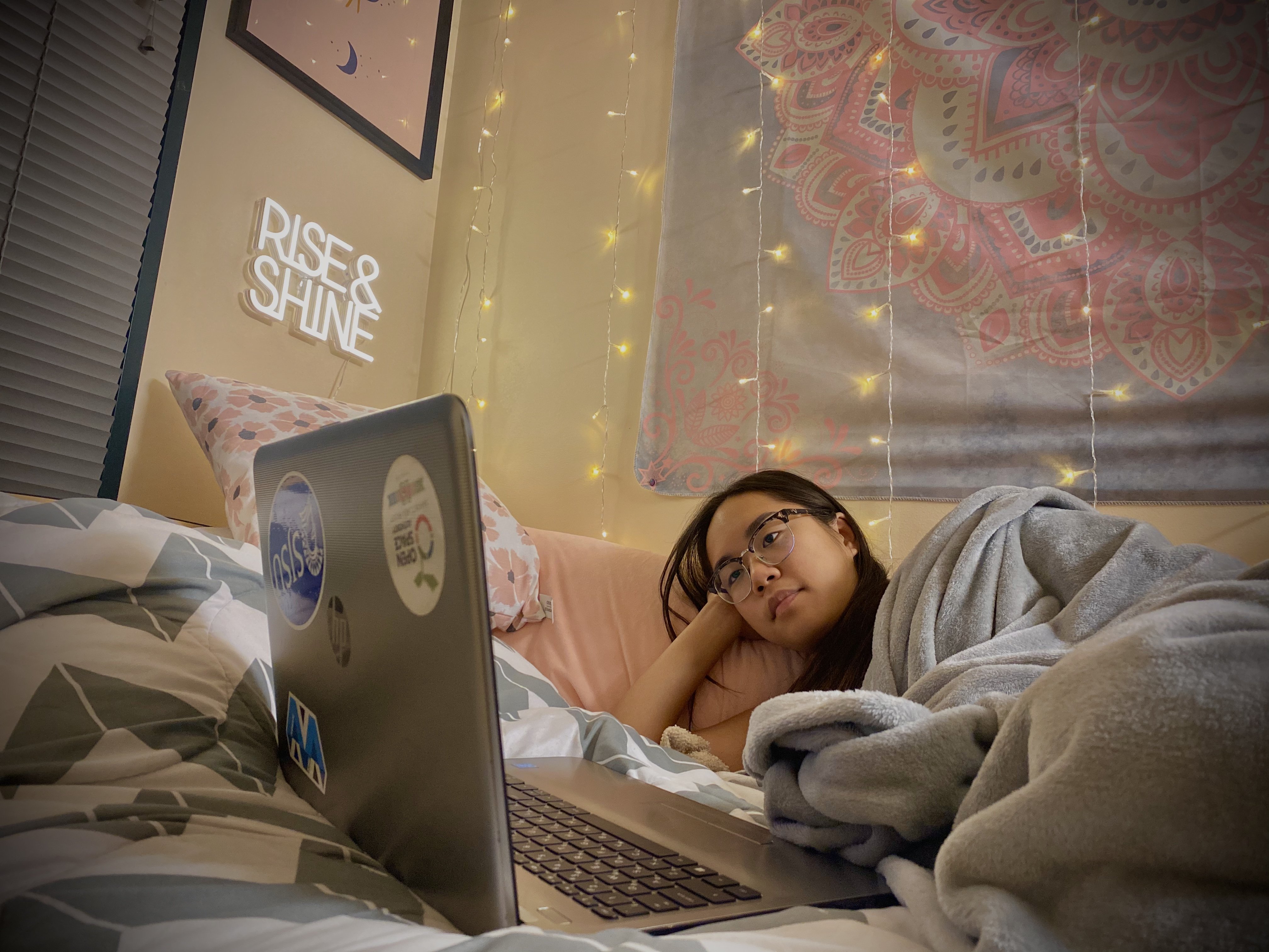 girl watching movie on laptop snuggled in blanket