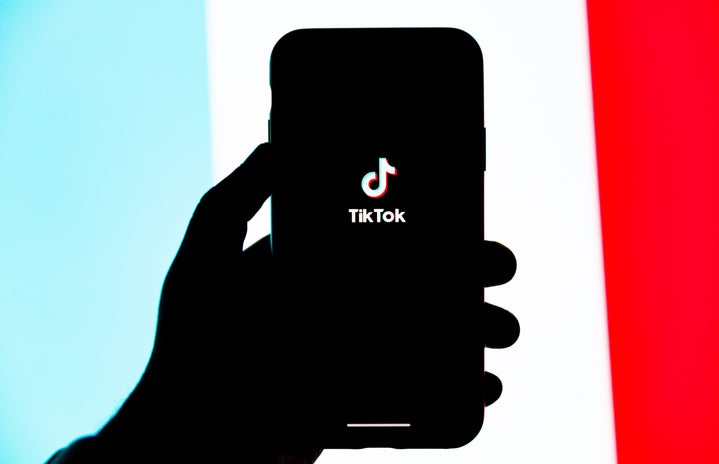 Hand holding phone with tik tok on screen