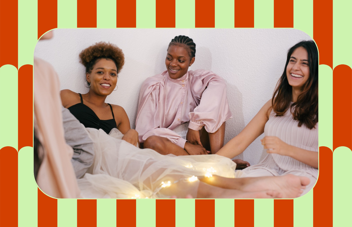 group of women laughing on bed
