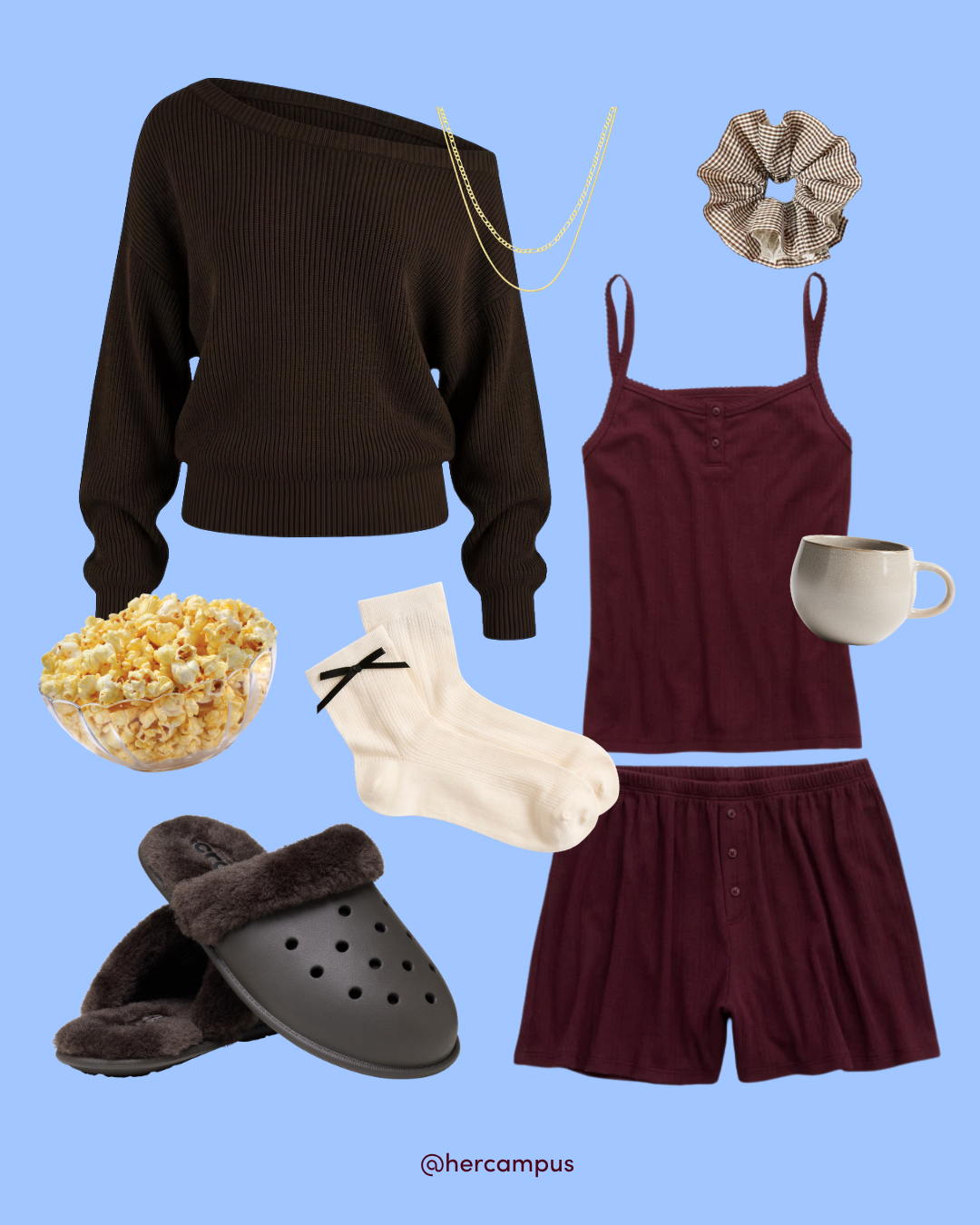 Flat lay on a blue background shows a cozy student outfit: dark sweater, burgundy tank and shorts, socks, slippers, scrunchie, mug, and popcorn, with a relaxed feel.