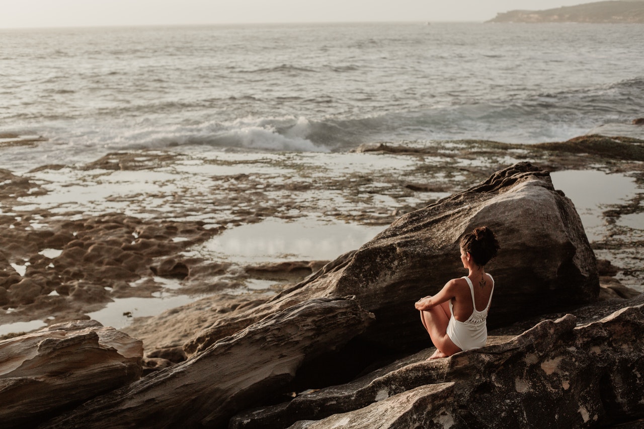 woman sitting on rock