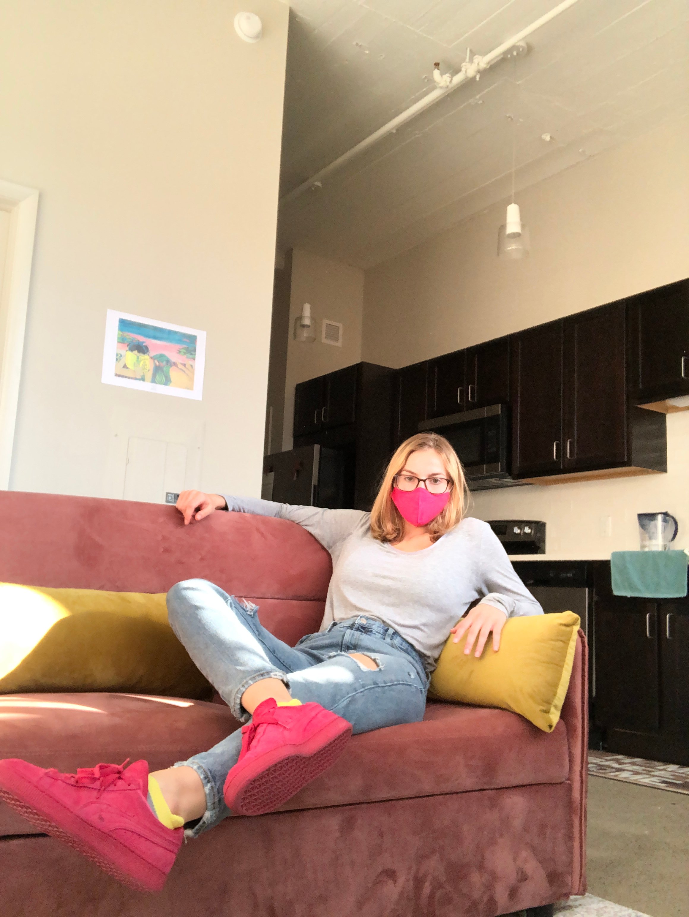 Girl sitting on couch with facemask on