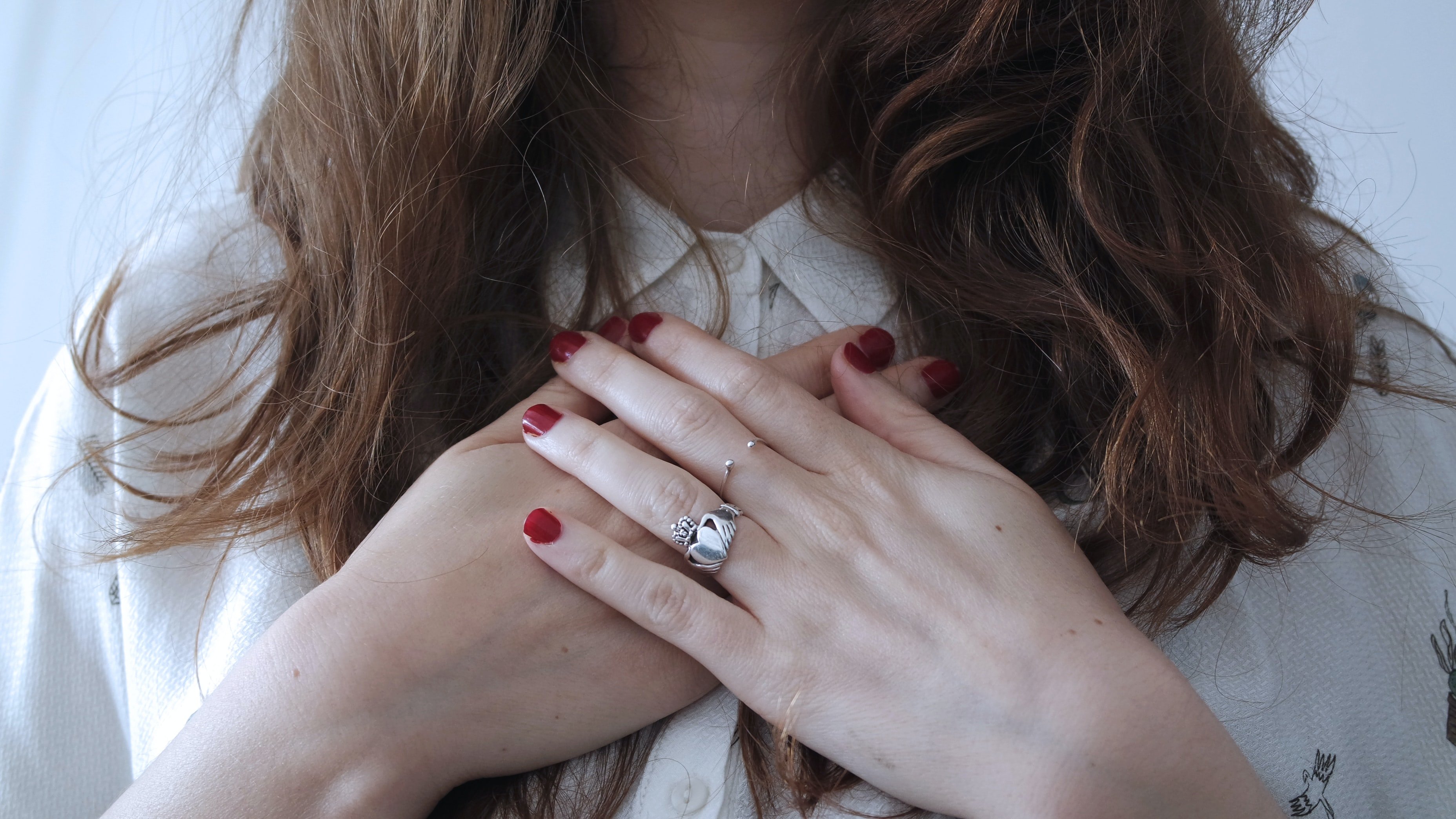 brunette girl with red nail polish and wedding ring