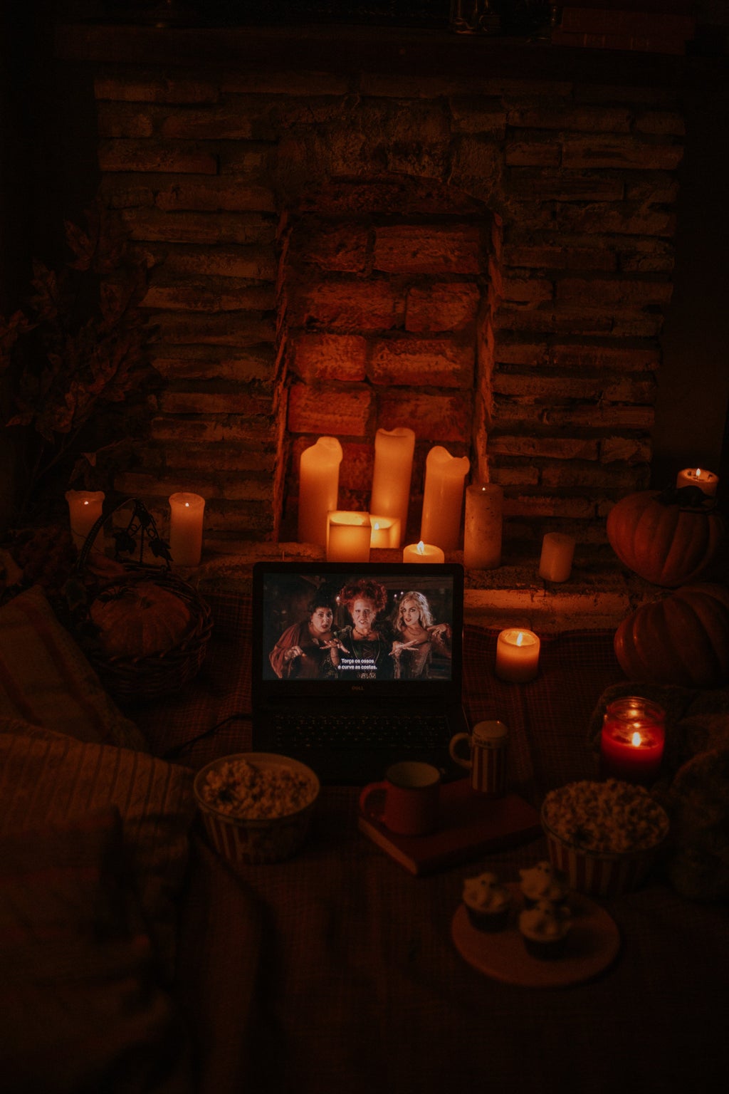 laptop playing "Hocus Pocus" in a room with candles and popcorn