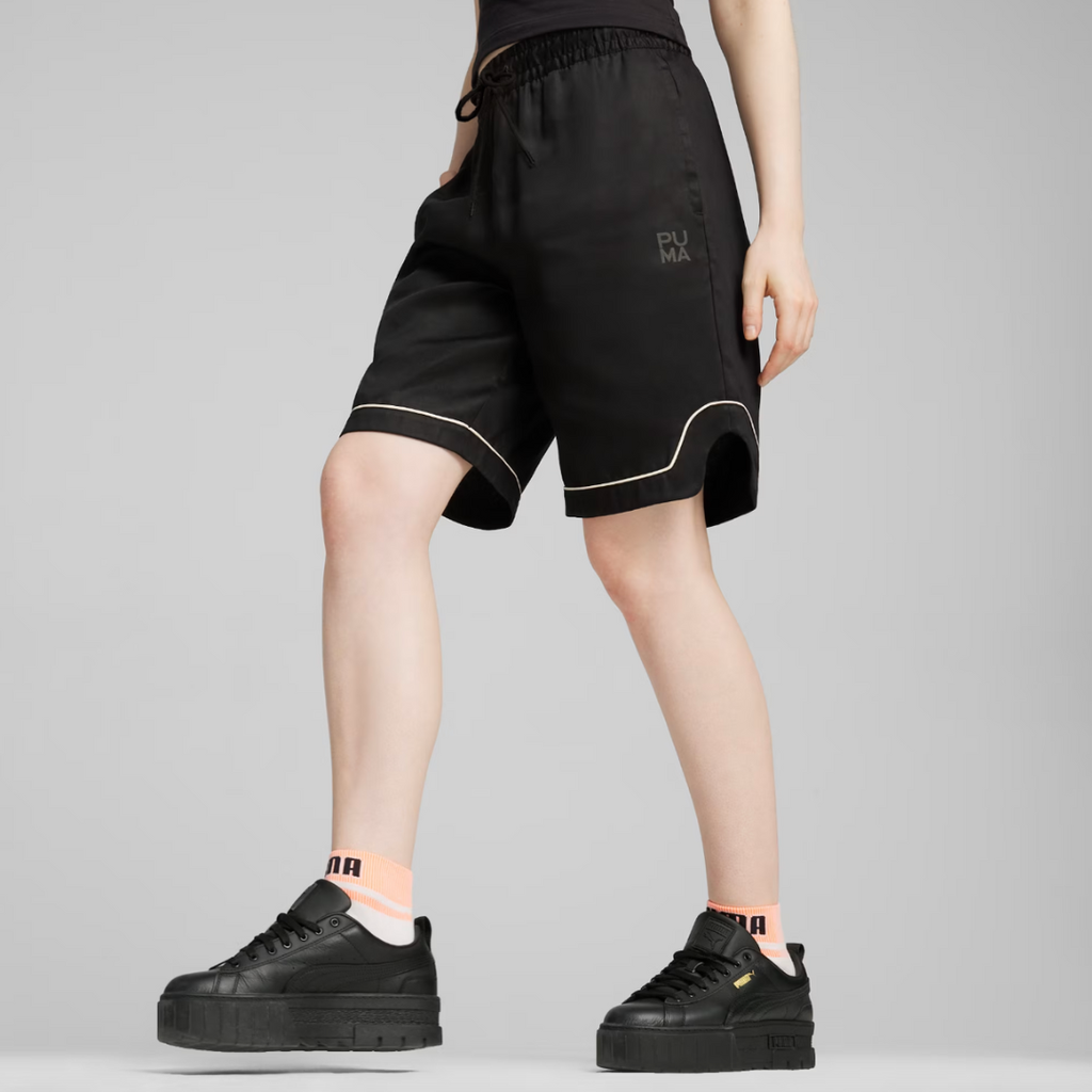 a person wearing black basketball shorts and black sneakers