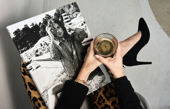 woman holding coffee with magazine