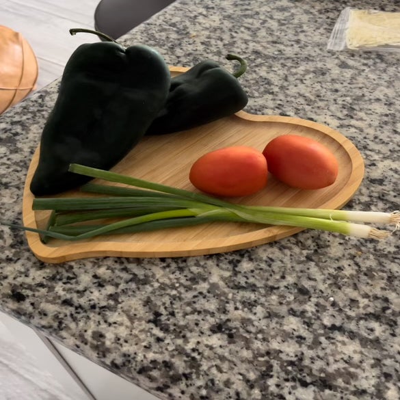 Assorted vegetables on heart shaped cutting board