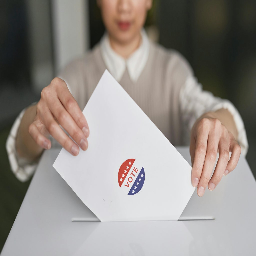 woman submitting voting ballot