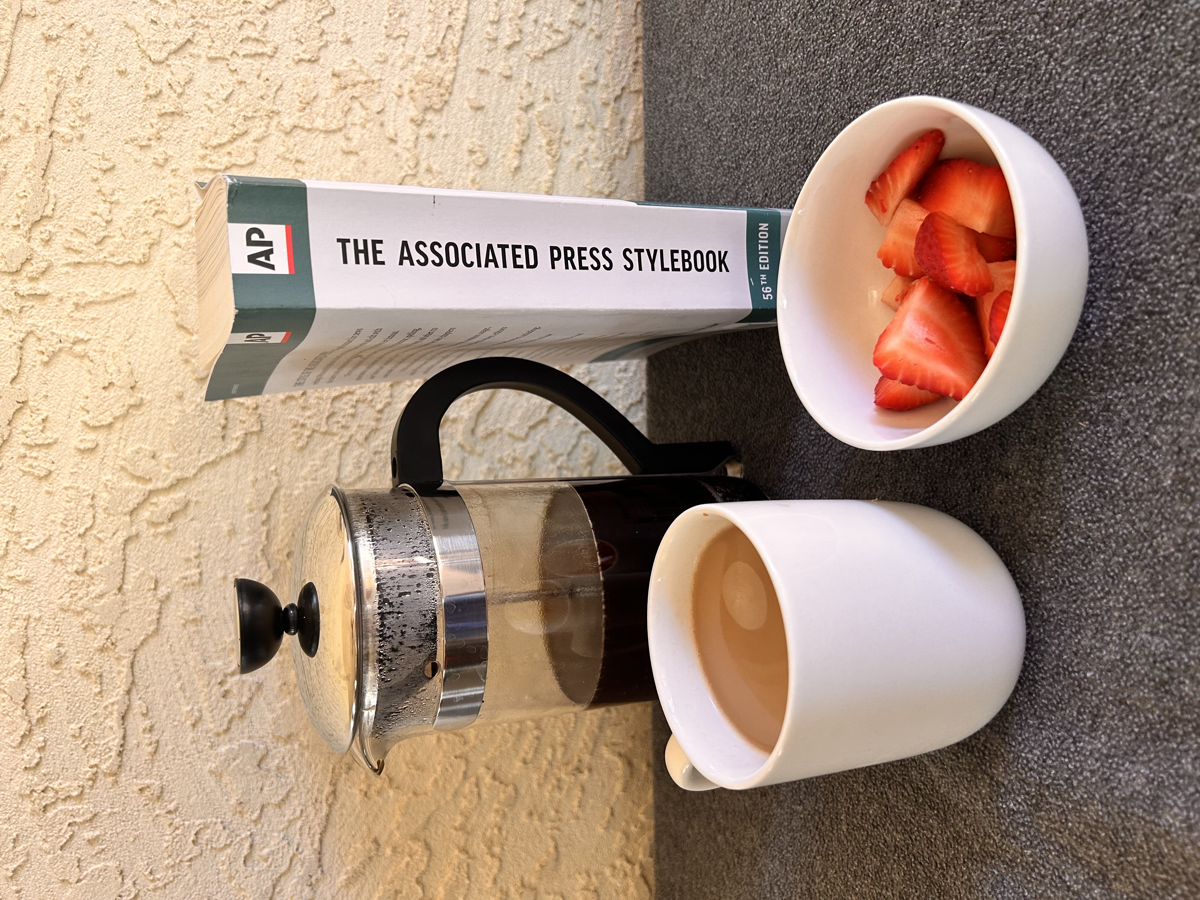 Bowl of strawberries, coffee, coffee press and AP Stylebook