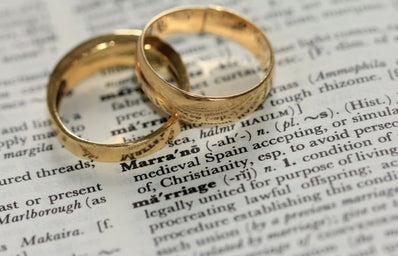 two wedding rings on top of writing