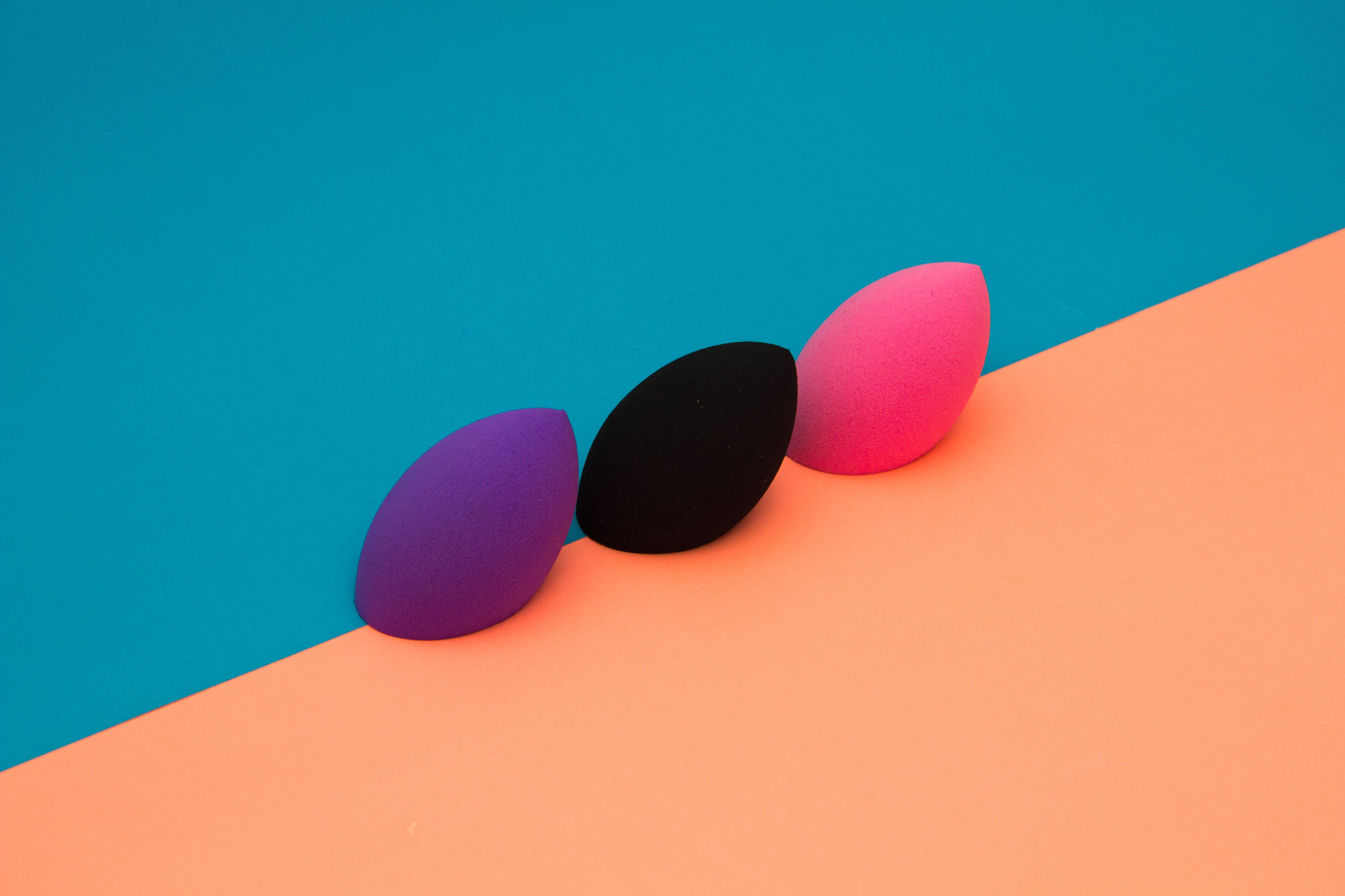 purple, black, and pink makeup sponges