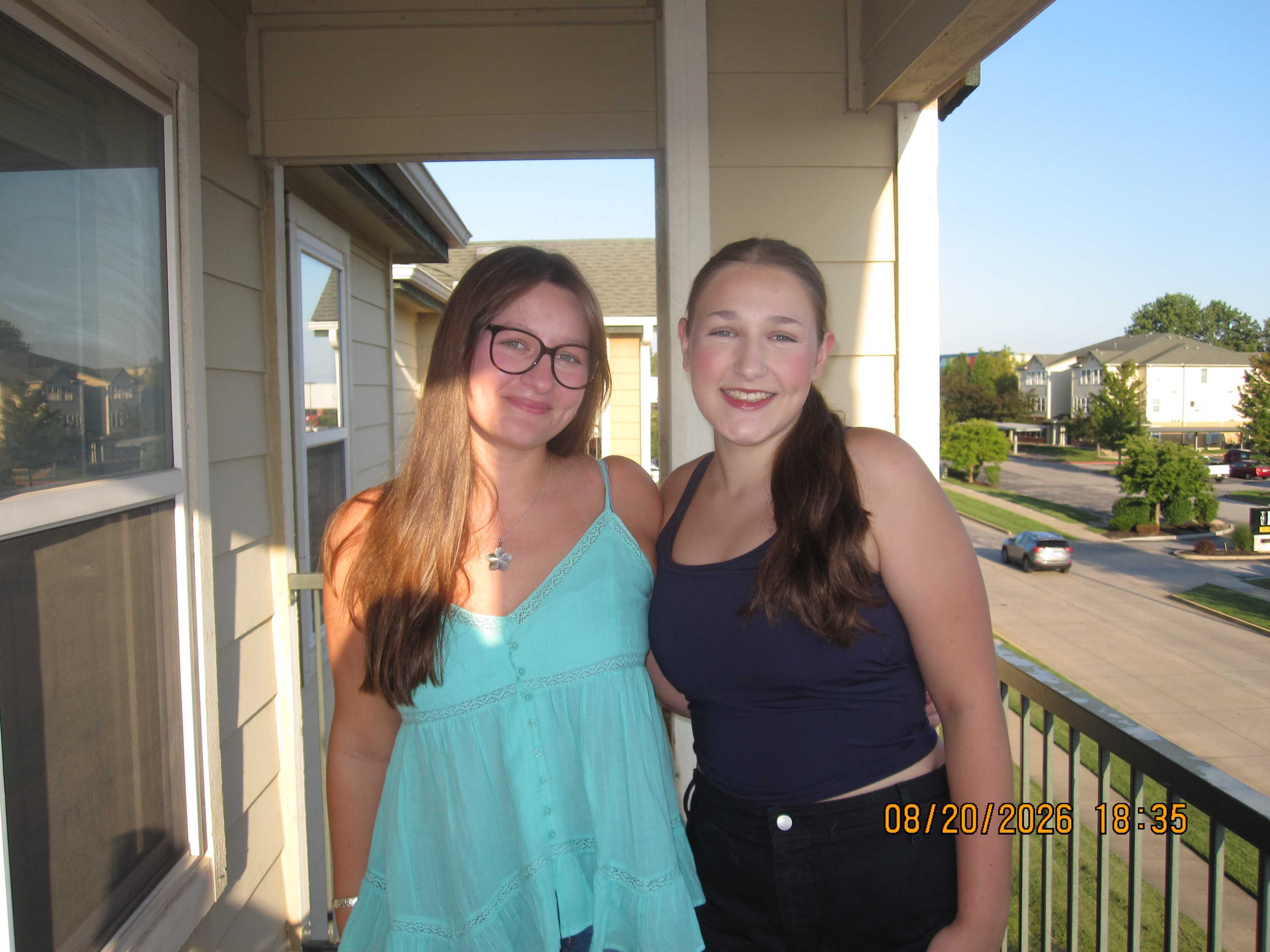 two girls posing on a balcony