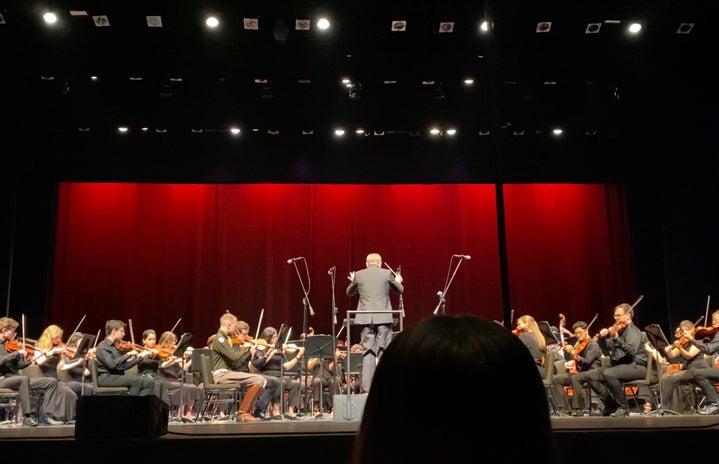 Image of the Texas A&M University Orchestra director and students performing in Fall 2022.