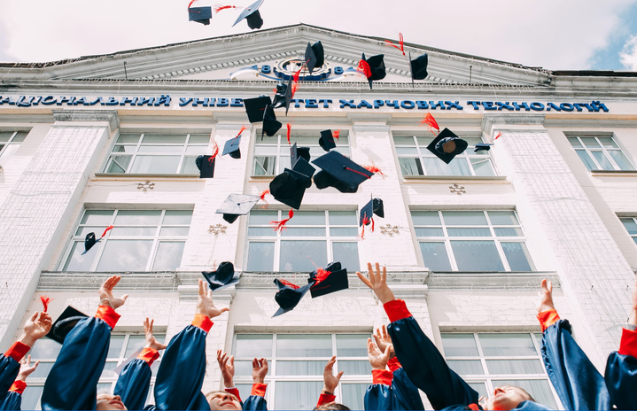 high school graduates throwing their caps