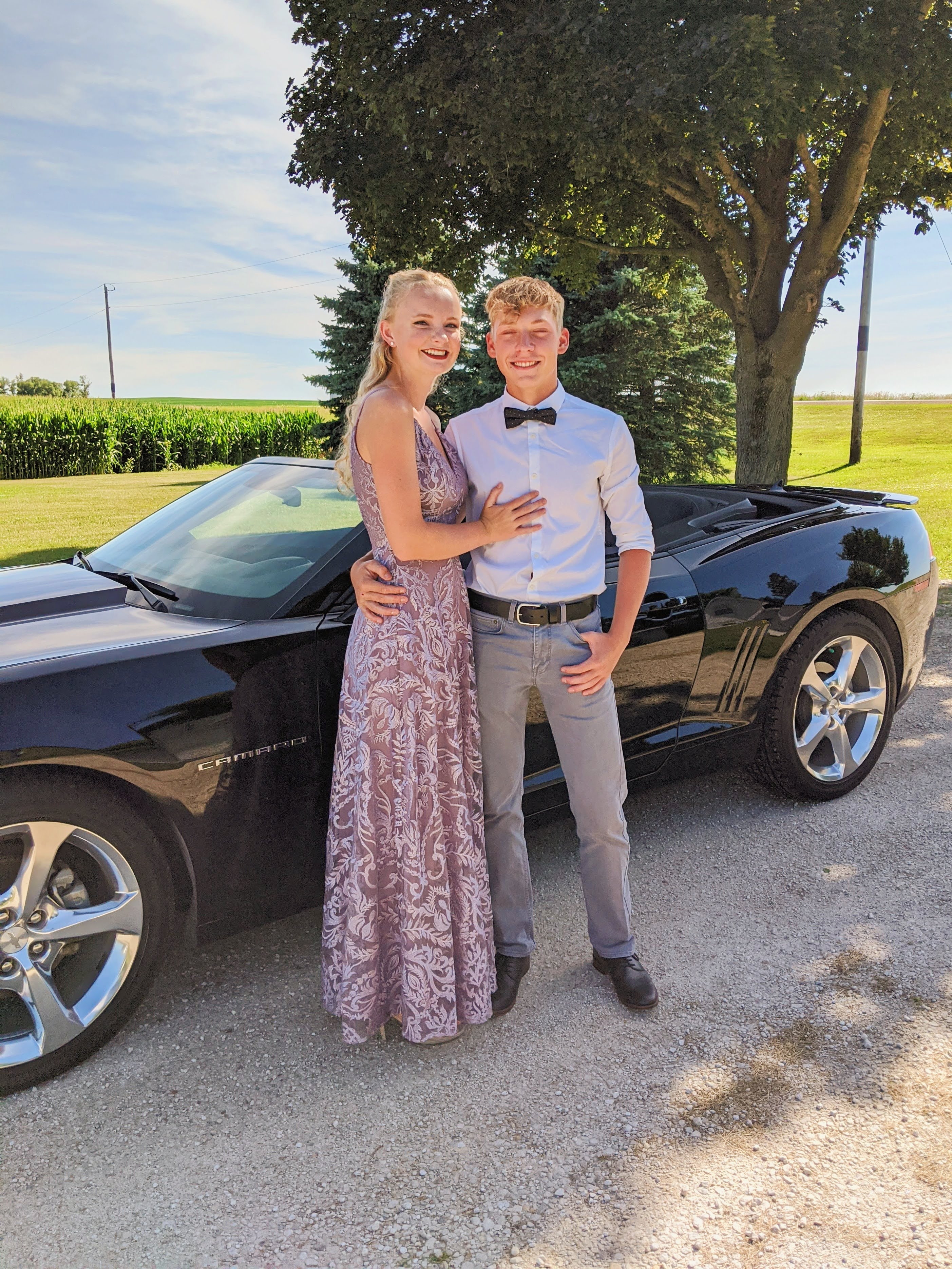 Brianna Strohbehn in her Pink/Champagne colored Prom Dress standing next to  her boyfriend.