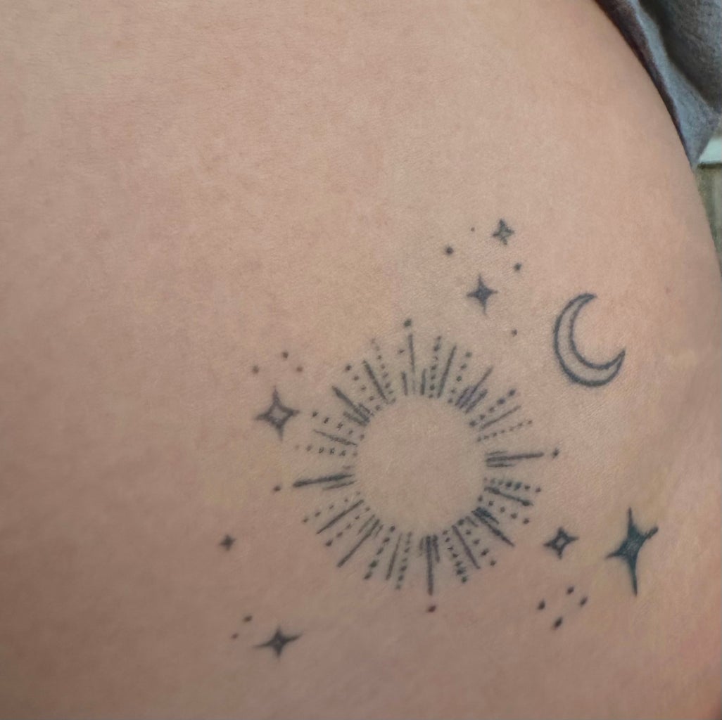 stars, moon, and sun tattoo on left hip