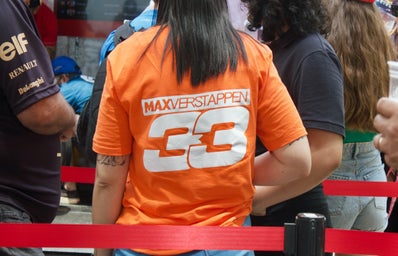 person wearing an orange shirt with \"max verstappen\" on the back