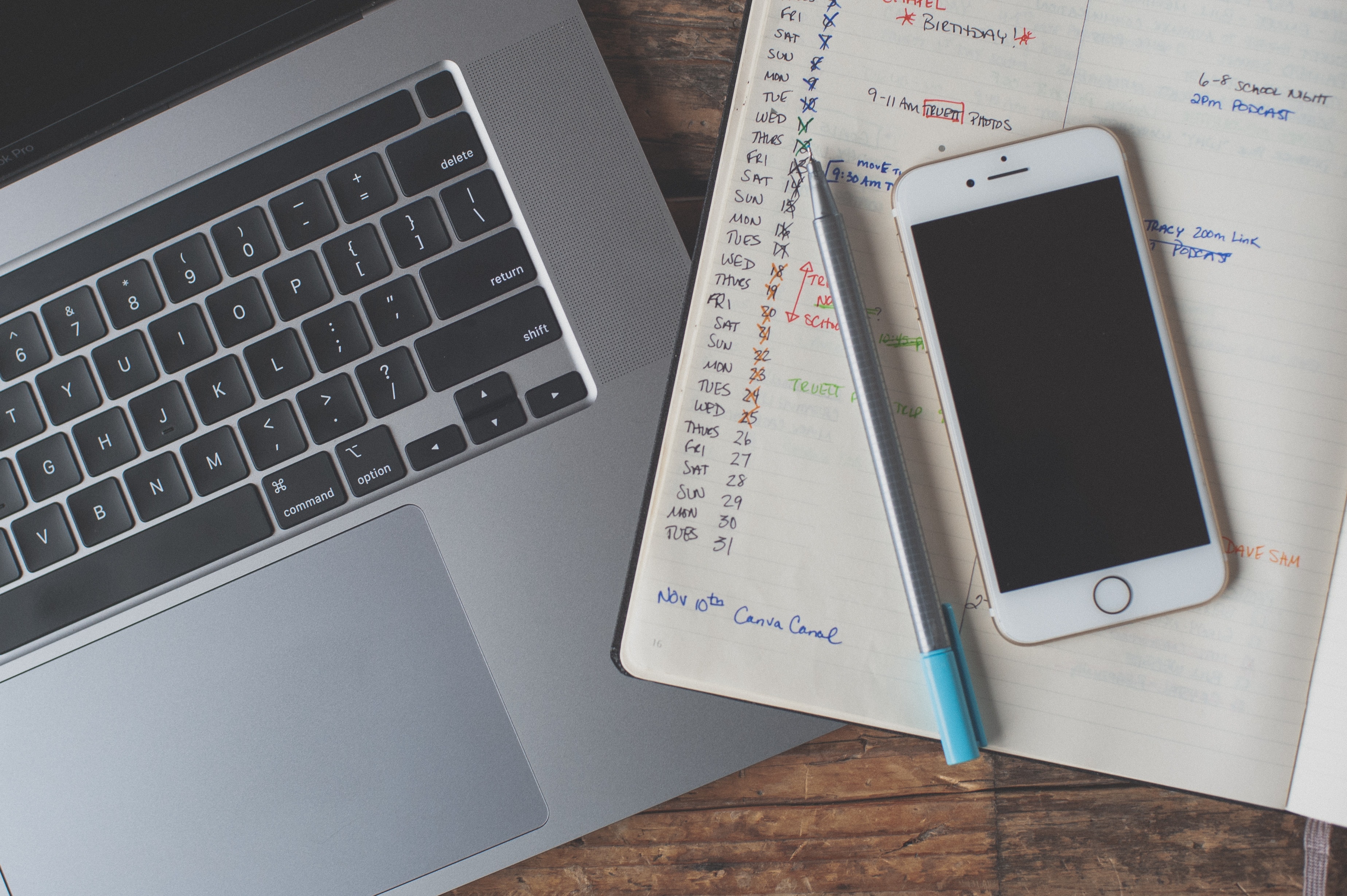 Planner, computer, and phone on a table.