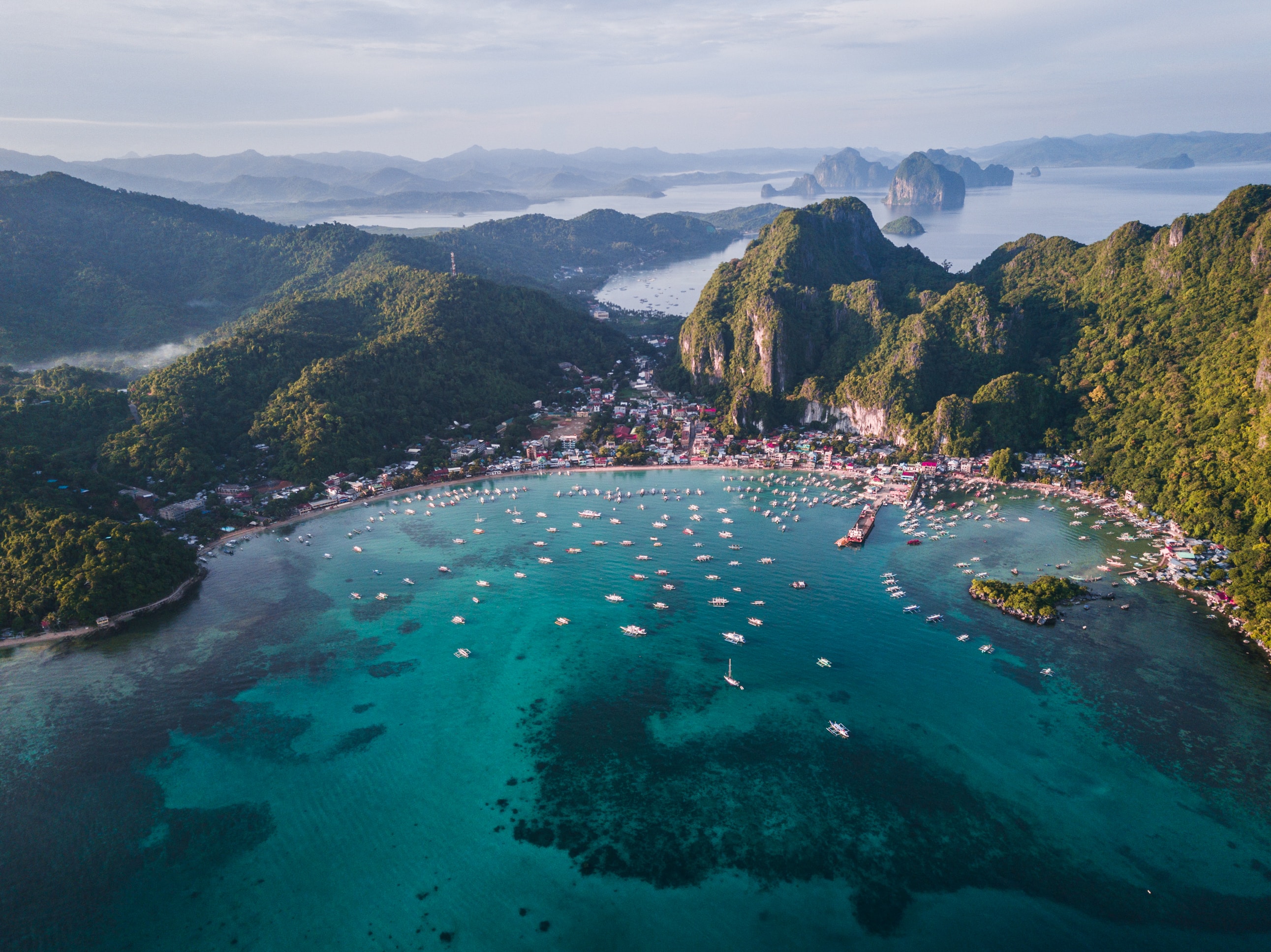 Ocean surrounded by mountains with boats in the water