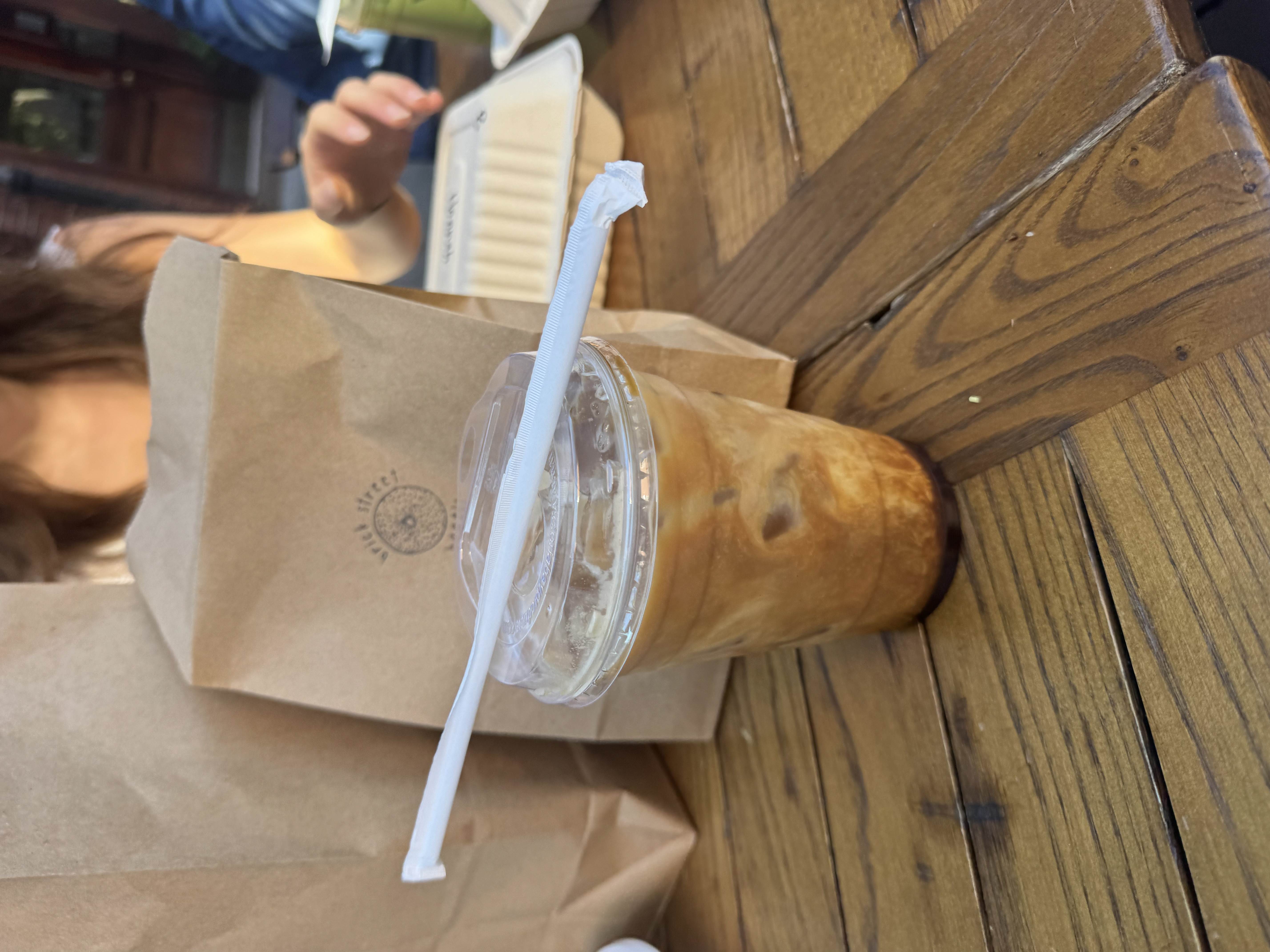 coffee on a table with paper bags in the back