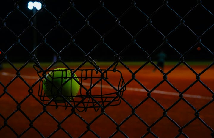Softball hung on fence