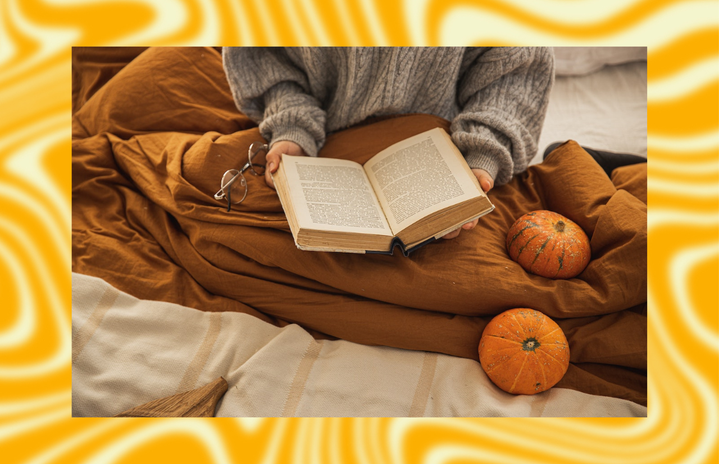 woman reading book with pumpkins and blanket